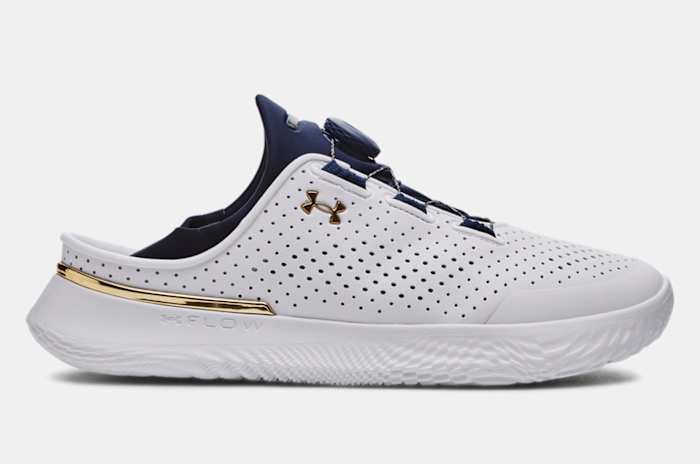 Side view of a white and navy Under Armour shoe.